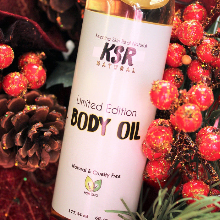 KSR Natural Winter Pom Body Oil displayed near wintery foliage in a 6 fl oz bottle